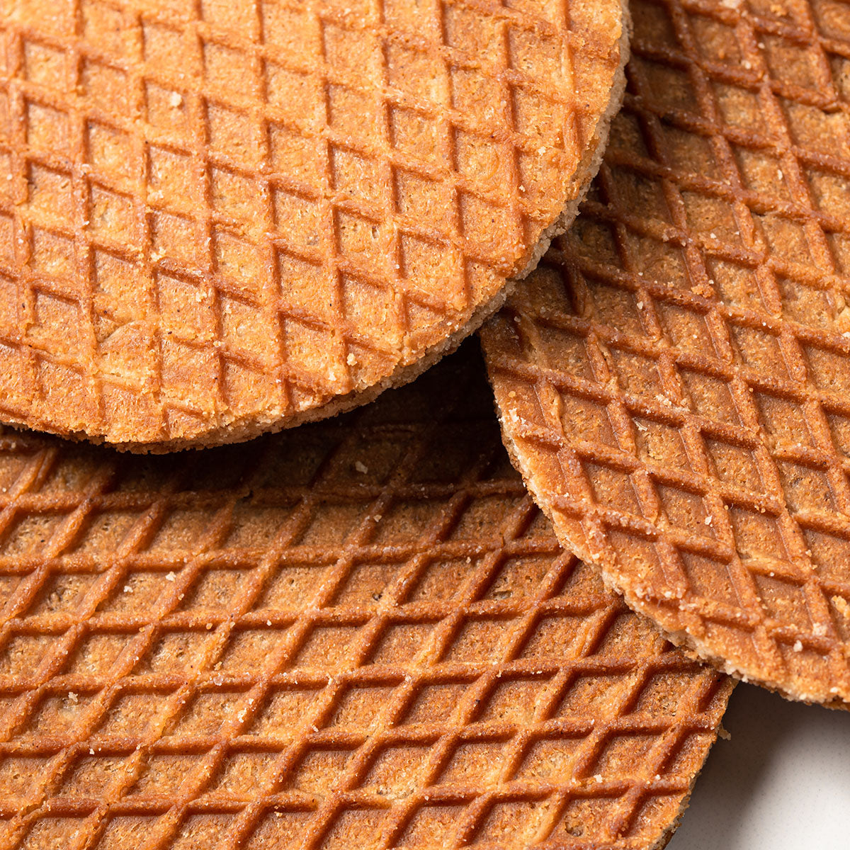 An authentic group of Double Authentic Mixed Tin Cans by Wonderen Stroopwafels on a white plate.